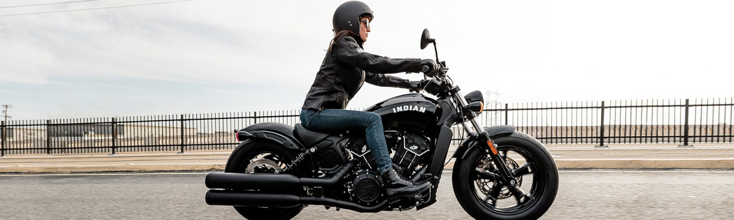 Woman riding a black 2022 Indian Motorcycle® Scout Bobber Sixty down the highway